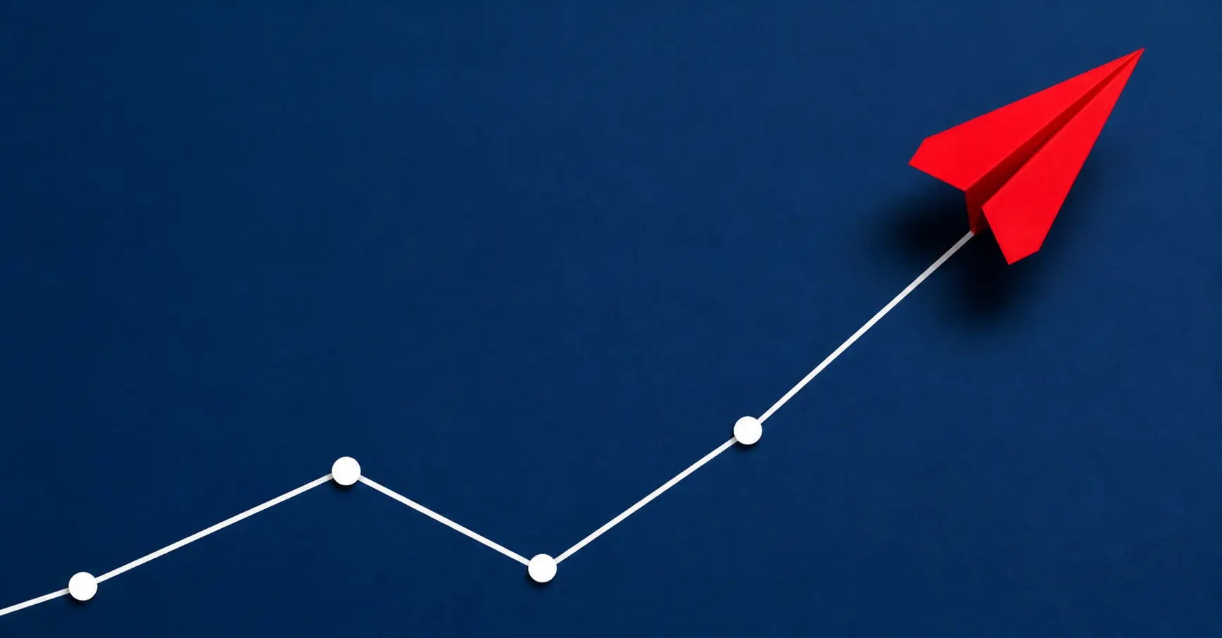 Red paper plane following a rising graph line
